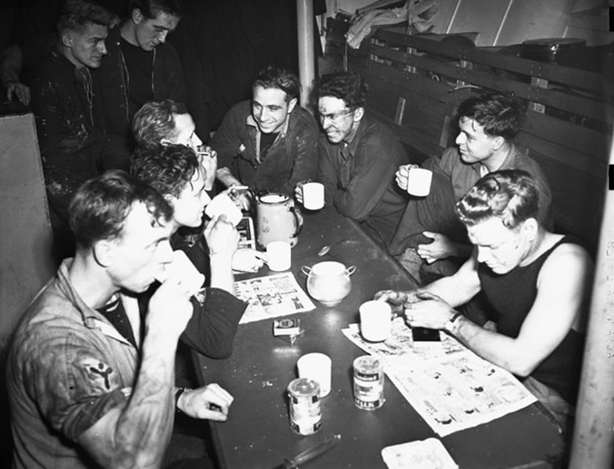 An image of several crew members eating their food in the ship’s mess hall