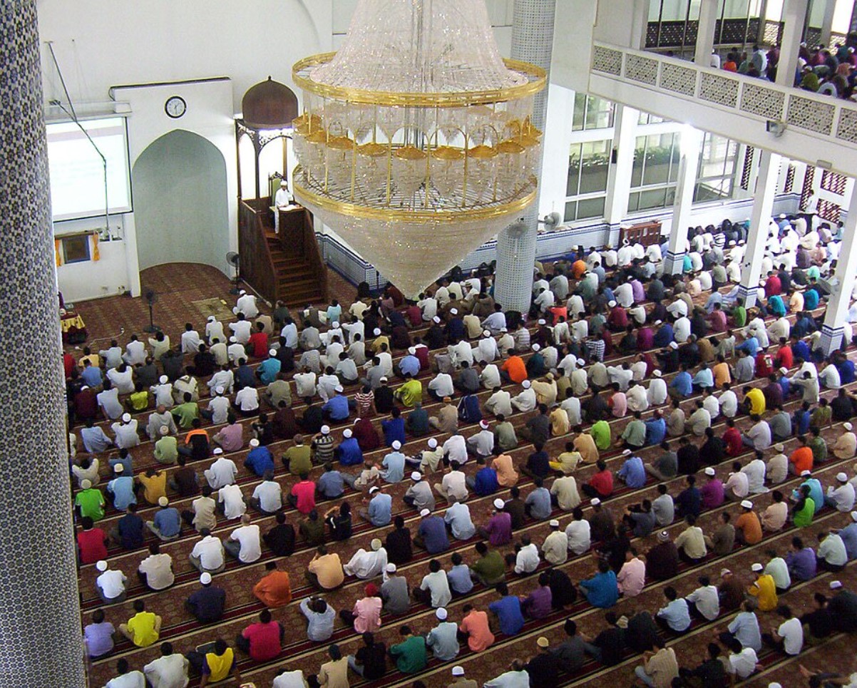 AN image of many Muslims praying in a building
