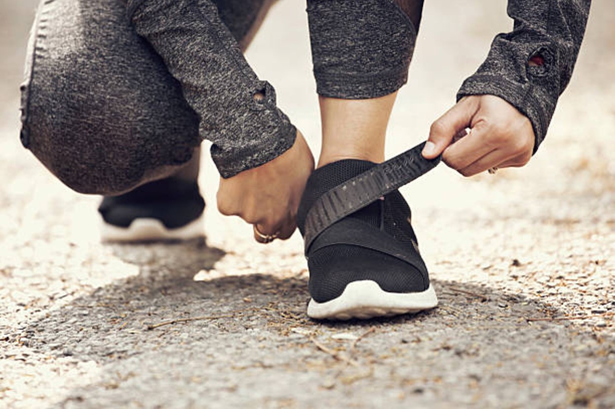 A runner stopping to velcro their shoes