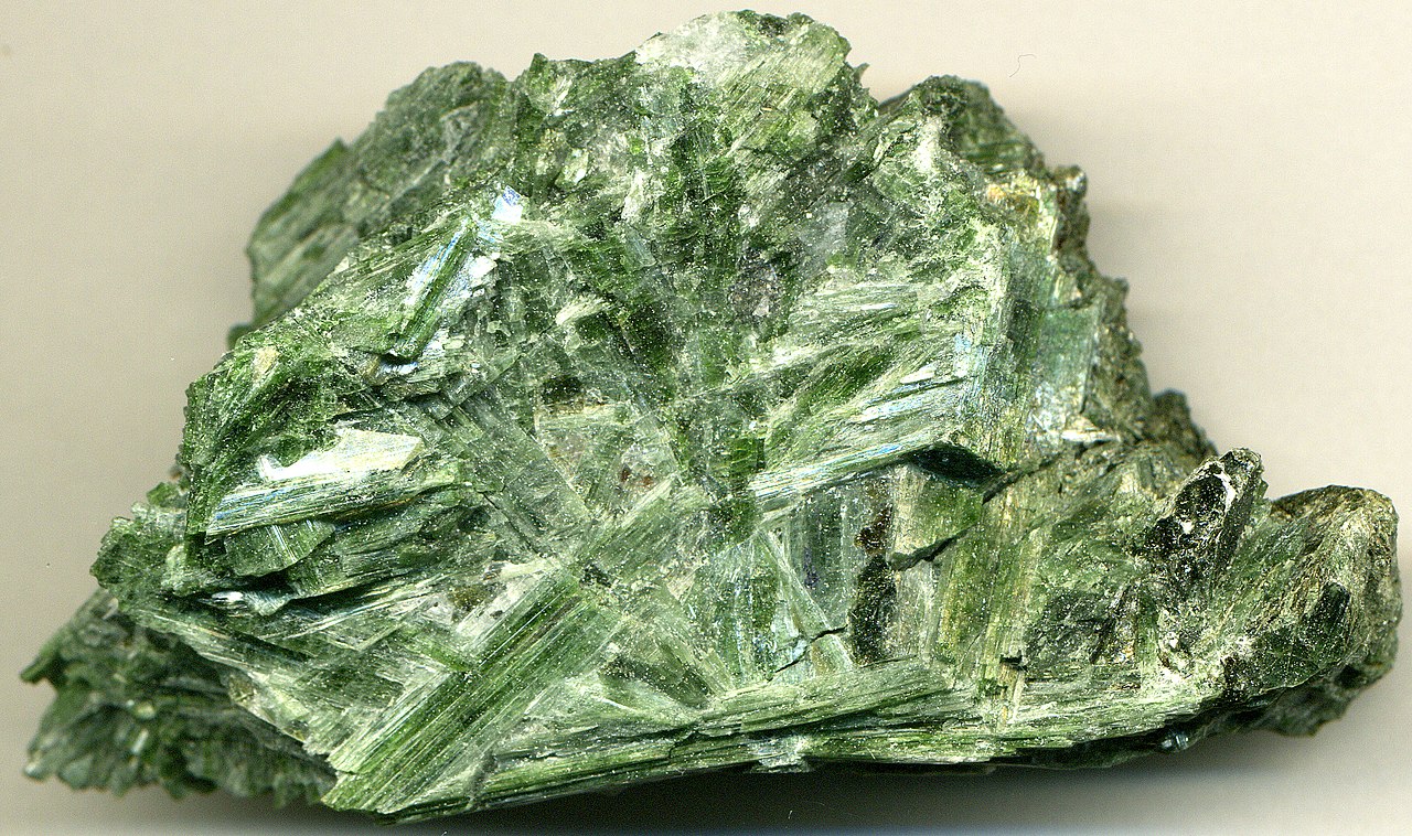 A large piece of uncut Actinolite is pictured on a small desk