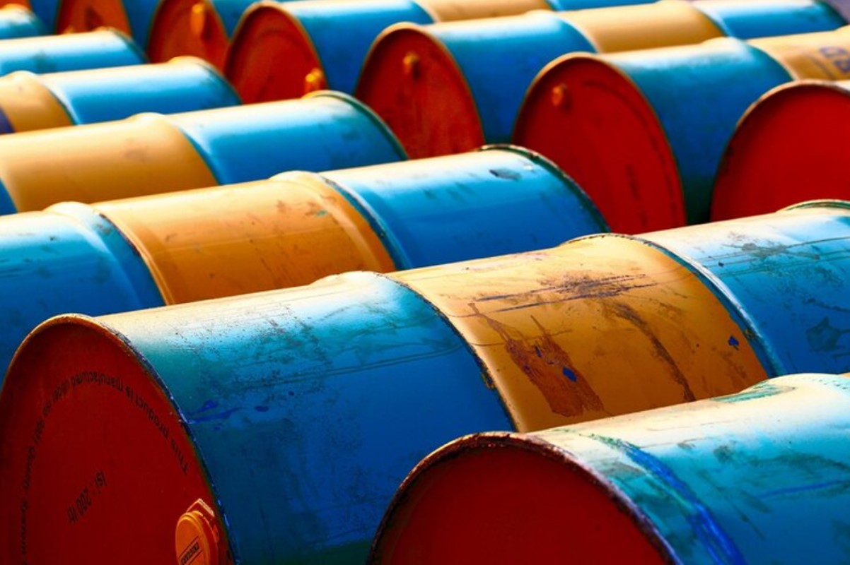An image of several barrels of oil laid on their side at a storage facility