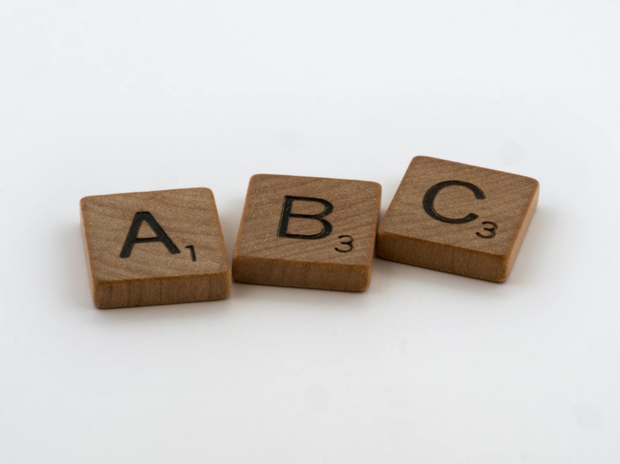 ABC letters made of wooden scrabble tiles on a white surface