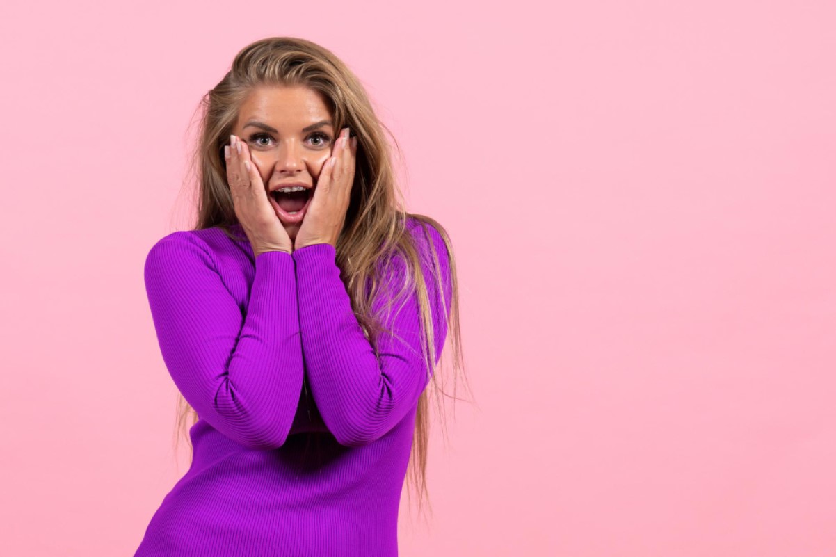 An image of a shocked woman in a purple sweater