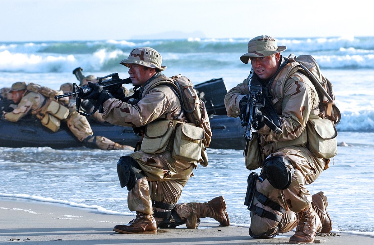An image of several Navy Seals landing on a beach