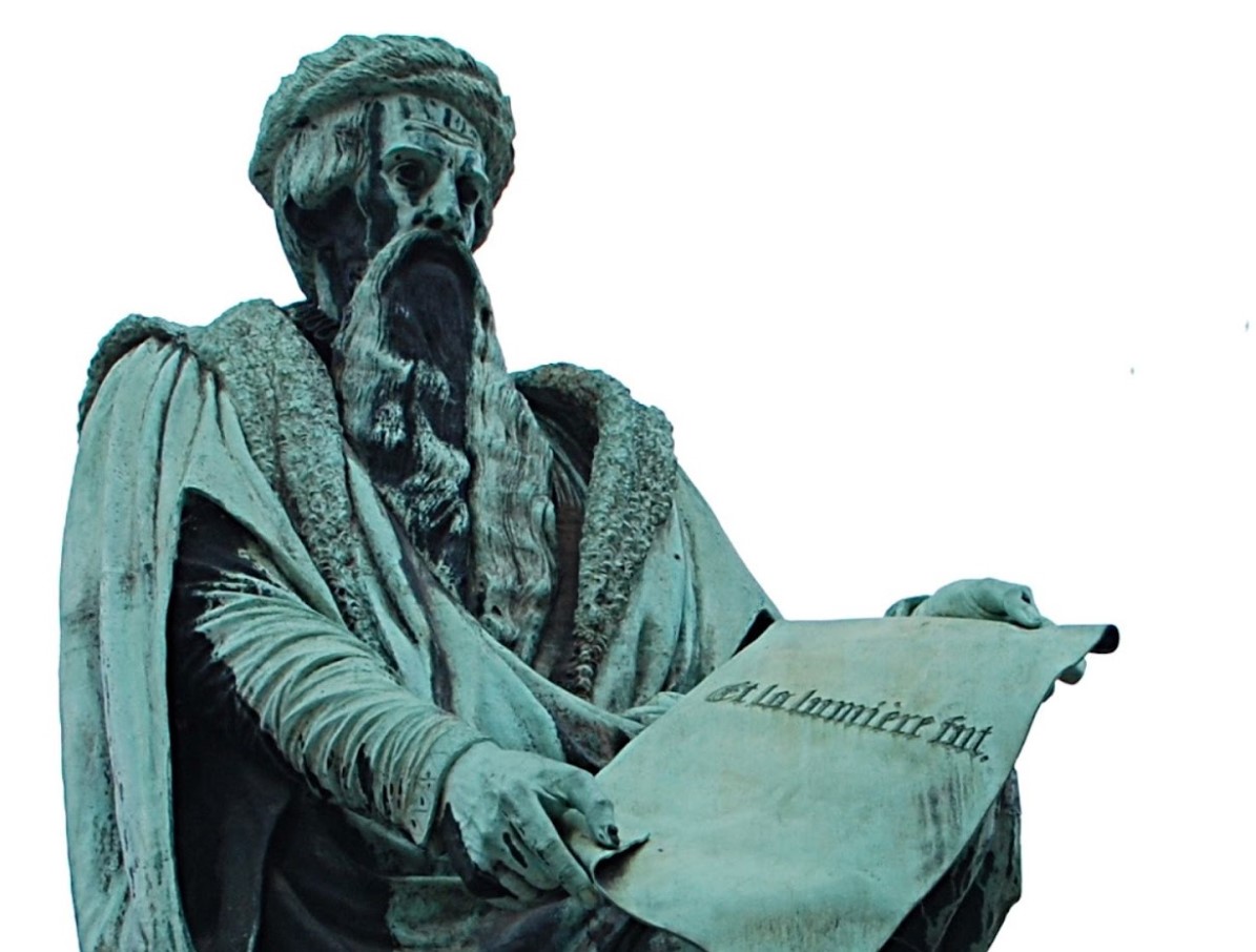 A statue of Johannes Gutenberg seen in the daytime.