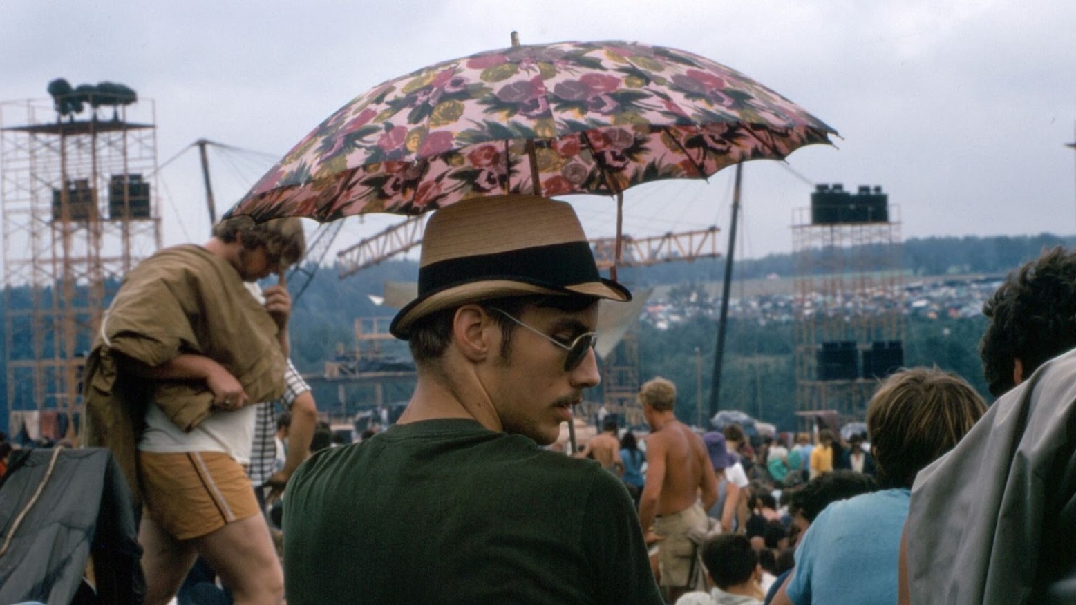 A man holding an umbrella above him while at the Woodstock festival in 1969.