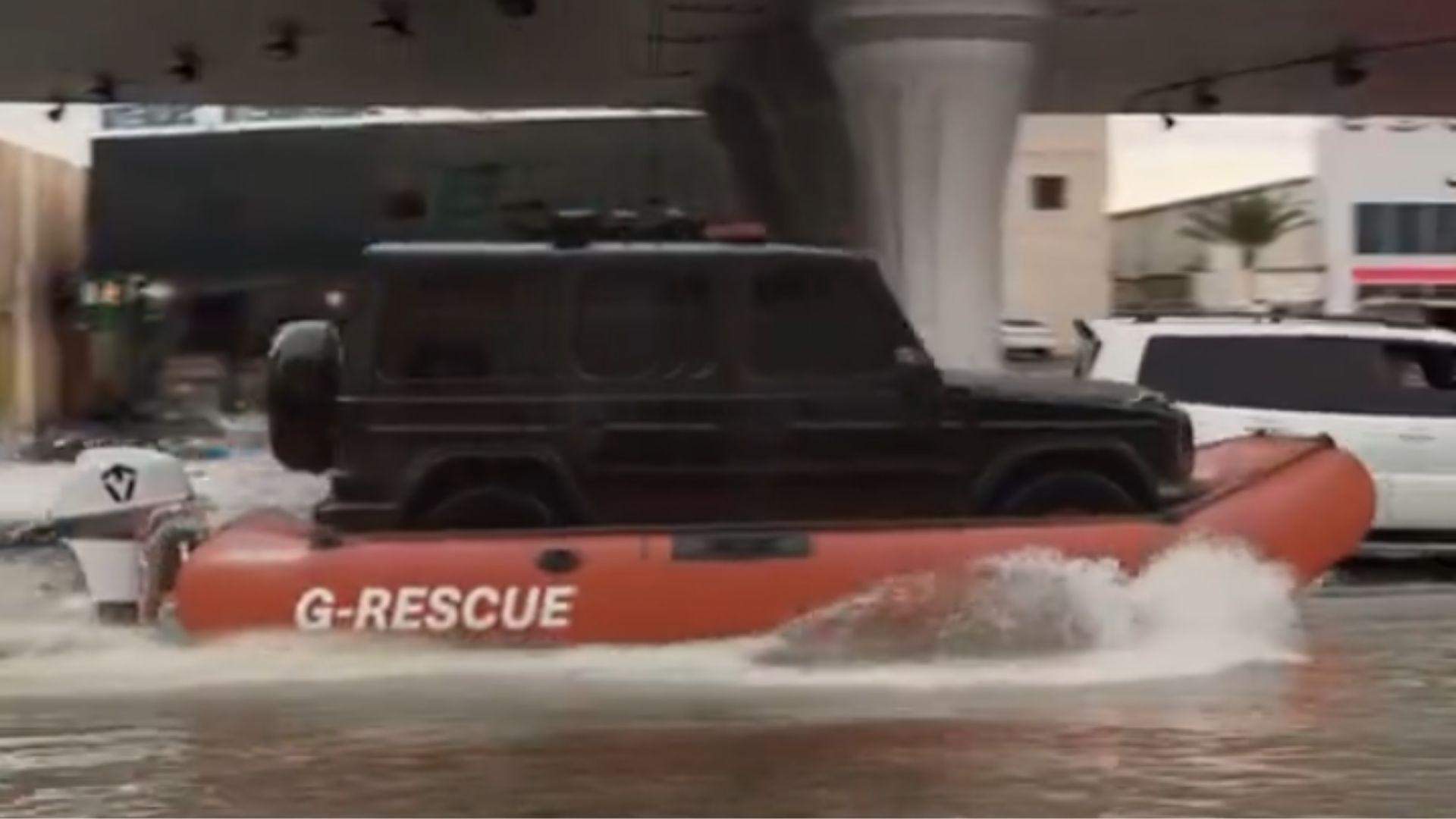 A black Jeep being transported through the Dubai floods on a red G-Resue boat.