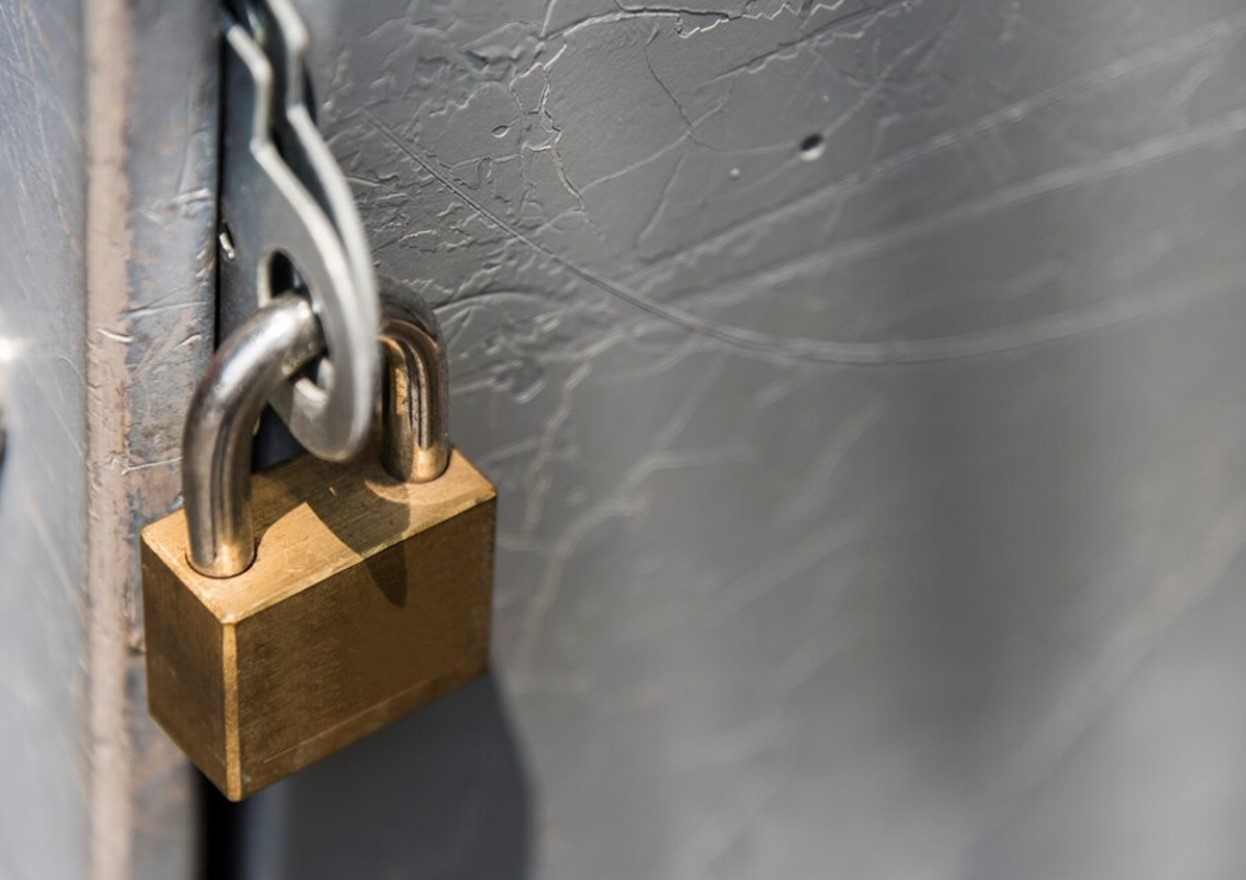 A padlock holds together a cement door