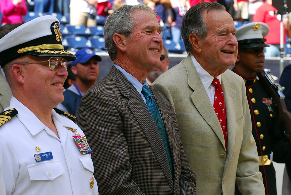 An image of Navy Captain Chil Miller, George W. Bush, and George H.W. Bush