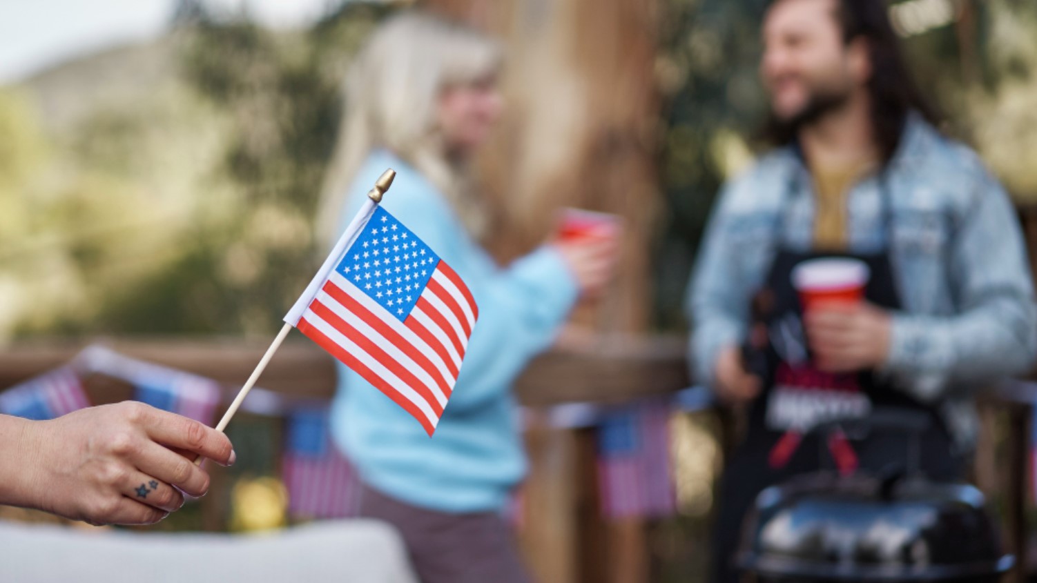 A woman is pictured holding a small American flag