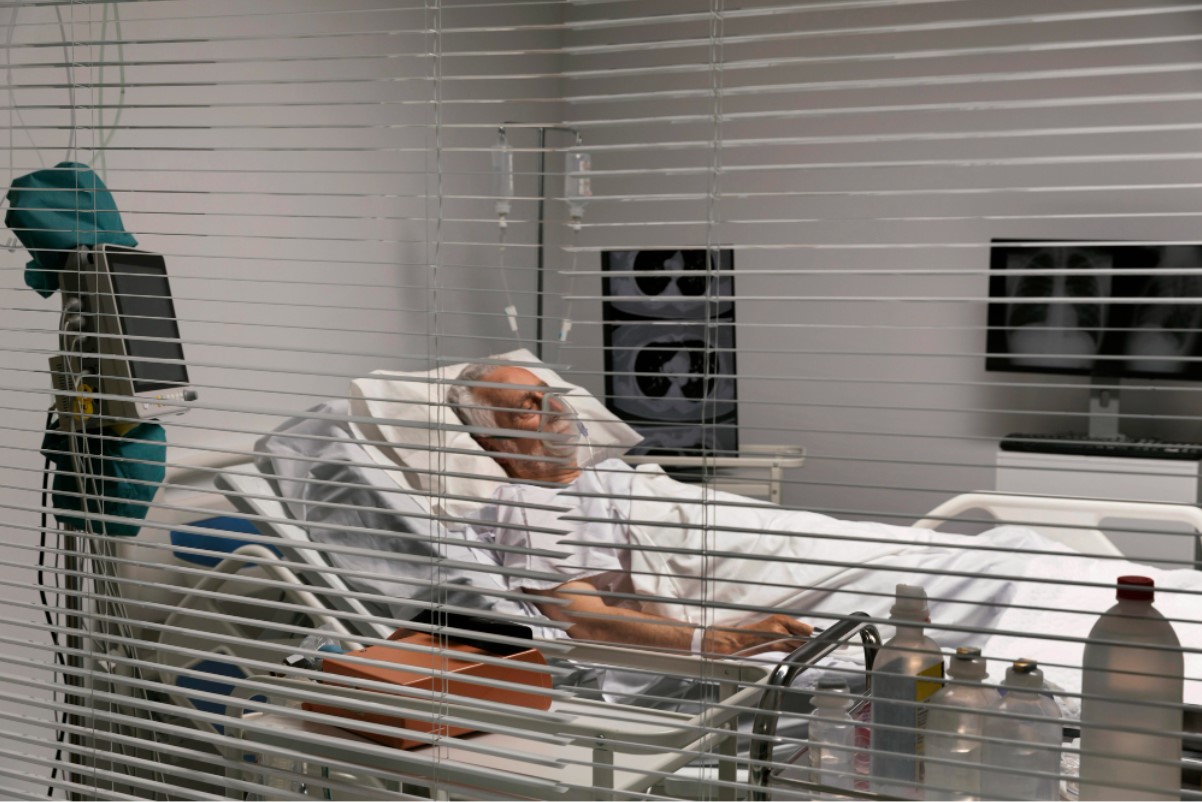 An older man is pictured lying in a hospital bed