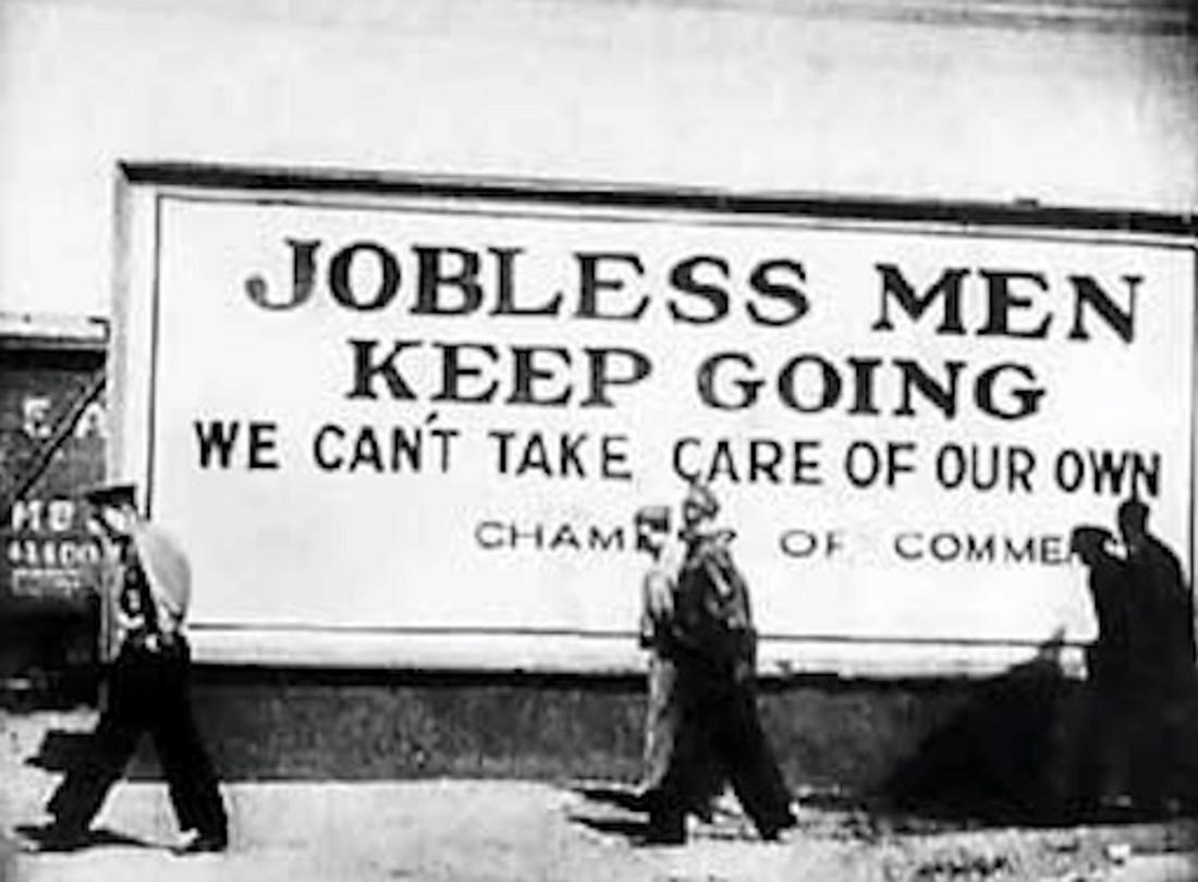Several American men walk by a sign that reads “Jobless Men Keep Going”