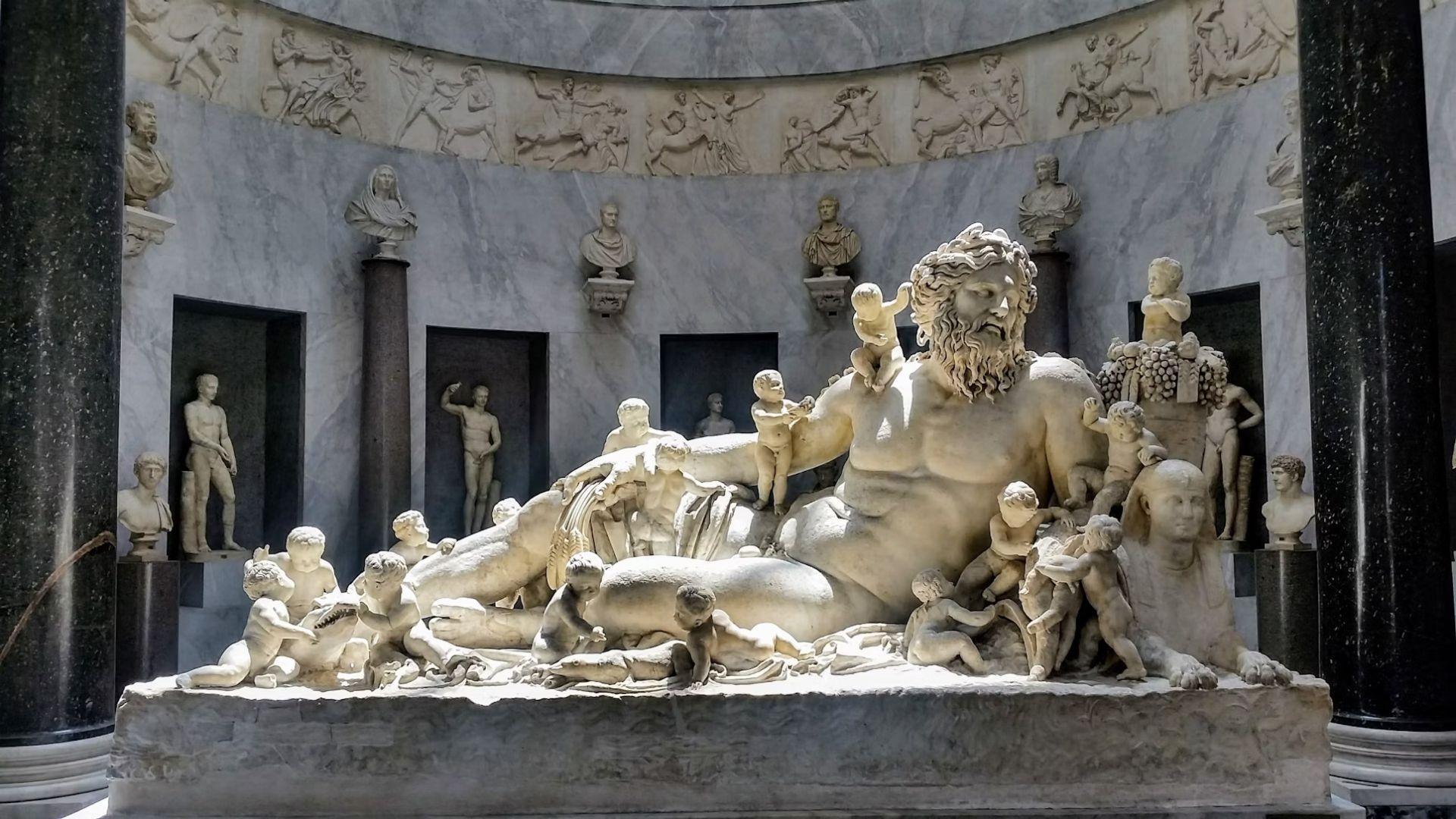 A statue showing an example of a Greek Titan surrounded by children.