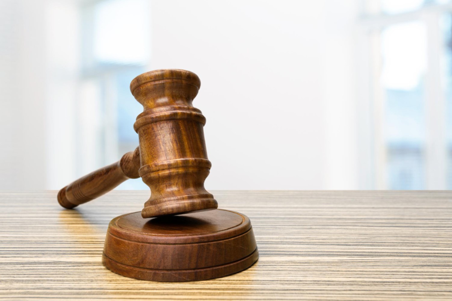 An image of a gavel which sits upon a wooden table