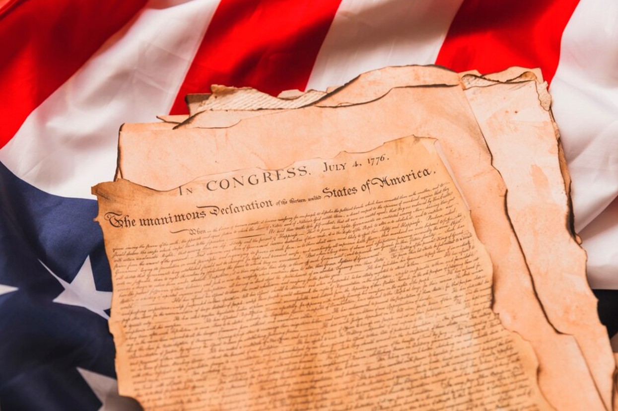 Photograph of the US Constitution atop an American flag
