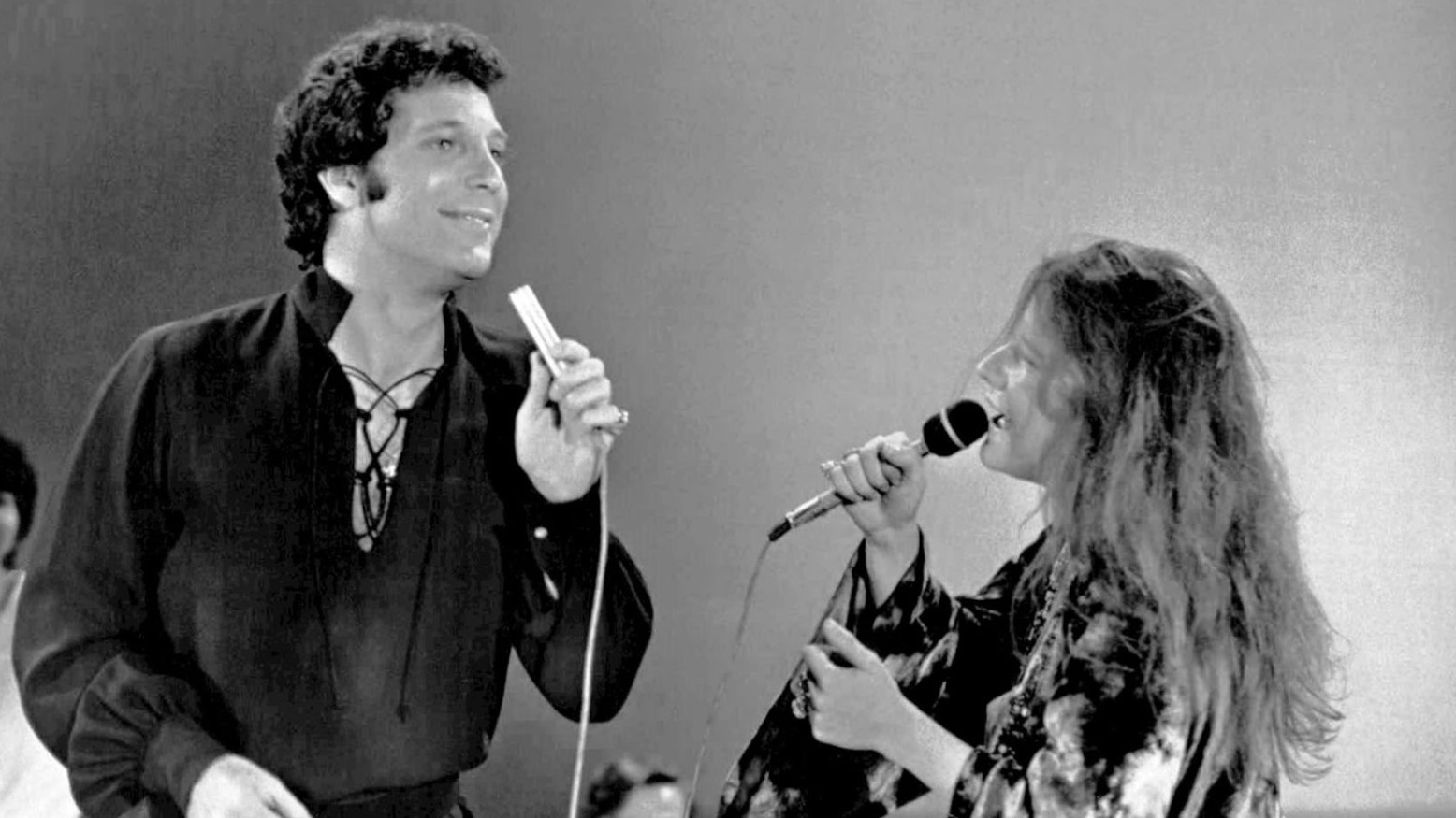 Tom Jones and Janis Joplin singing into microphones in 1969.