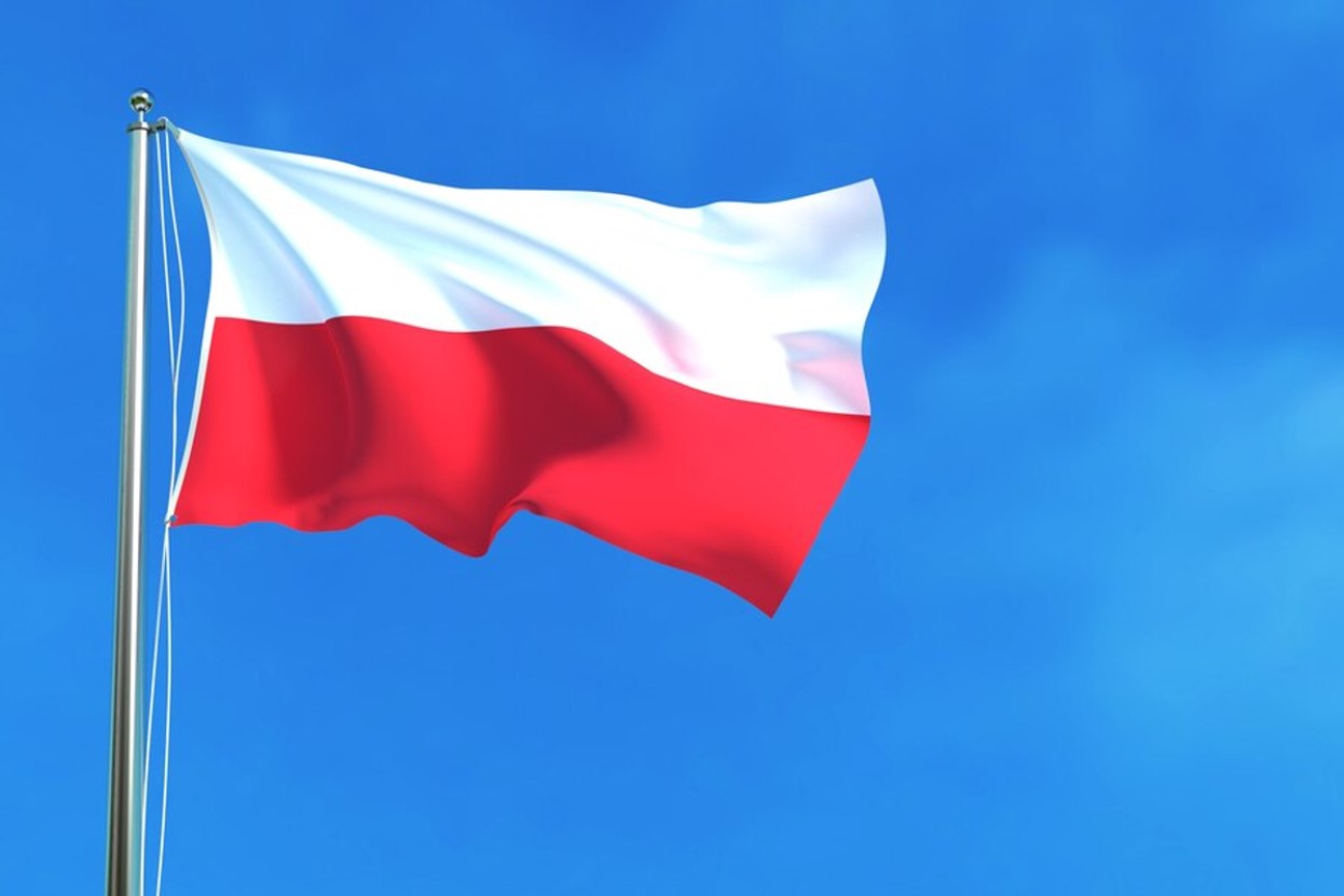 The flag of Poland flying against a bright blue sky