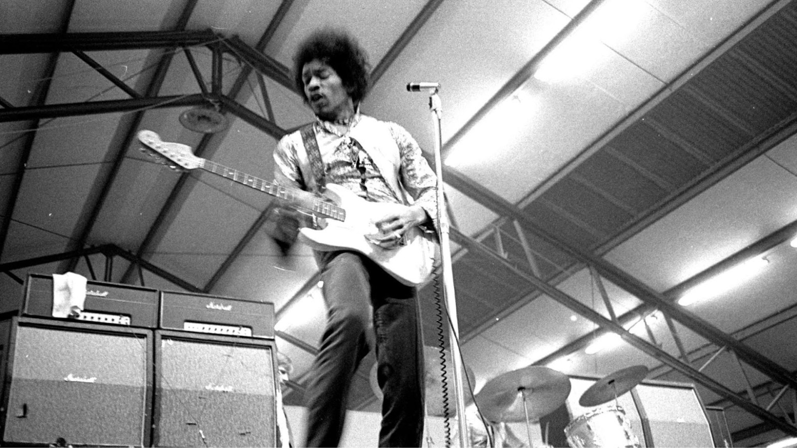 Jimi Hendrix playing a guitar and singing in 1967.
