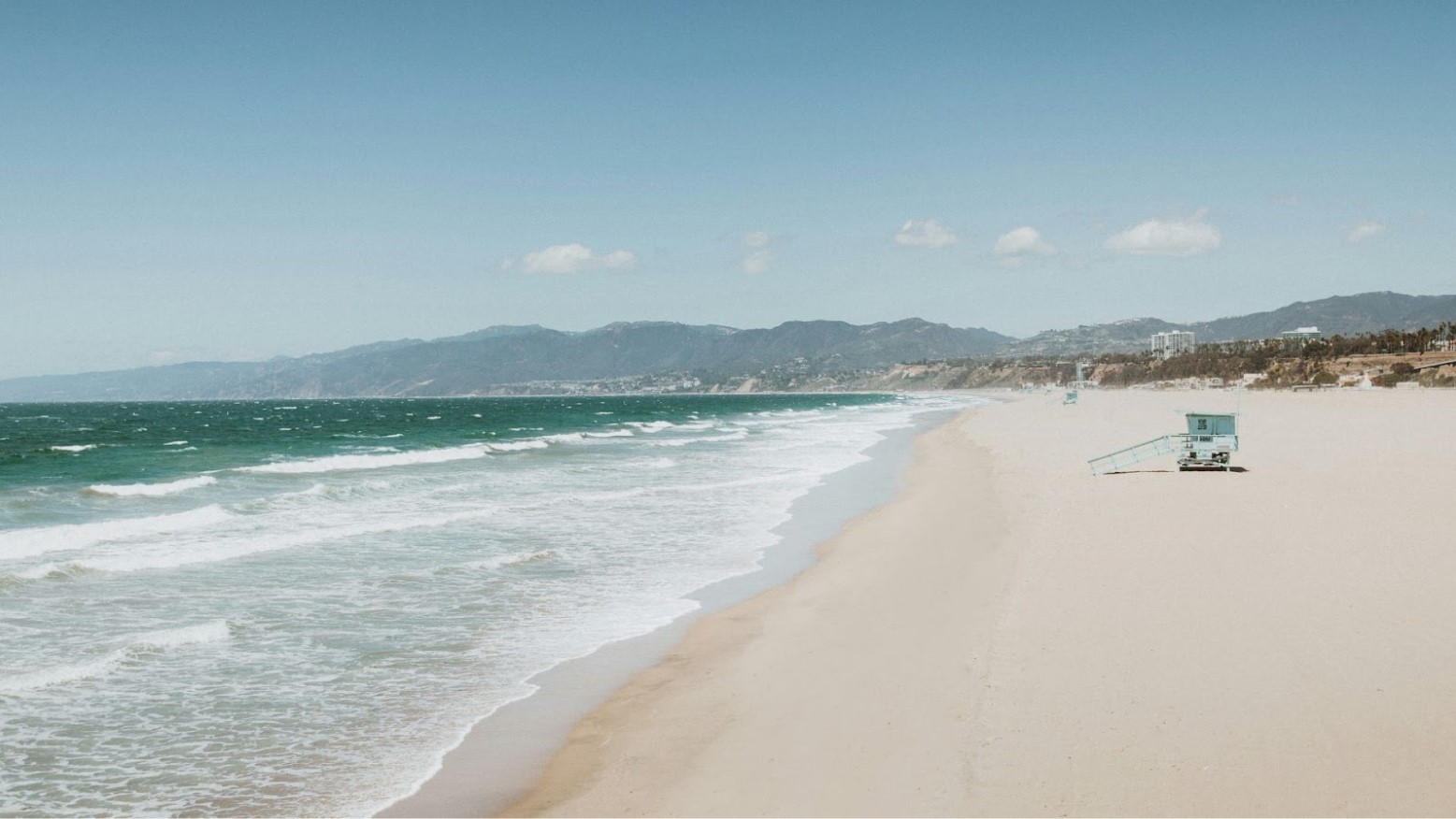 An empty beach in Santa Monica, California seen in the daytime.