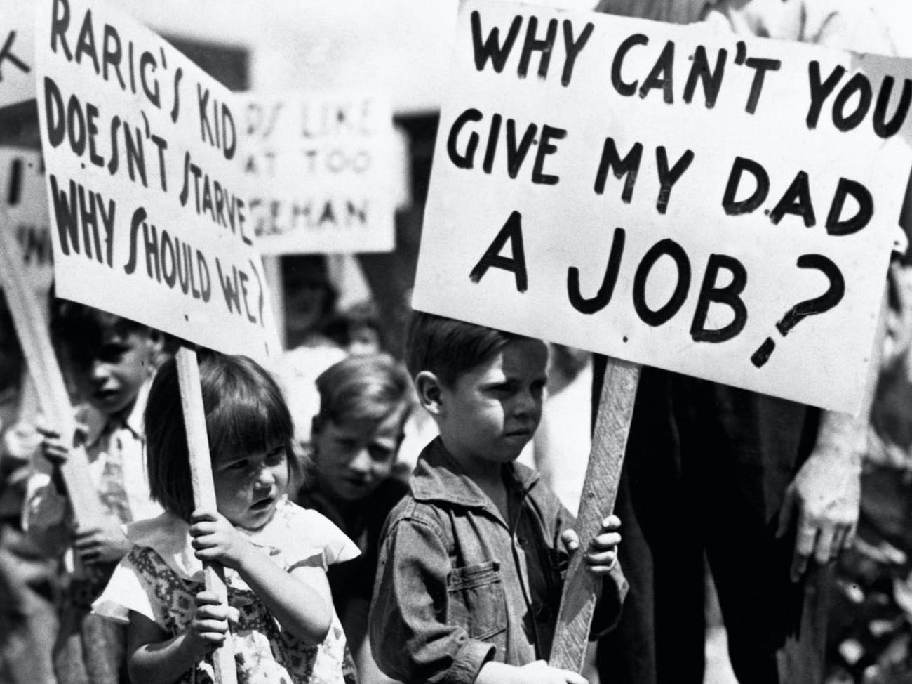 Children during the Great Depression holding signs that read “Why can’t you give my dad a job?”