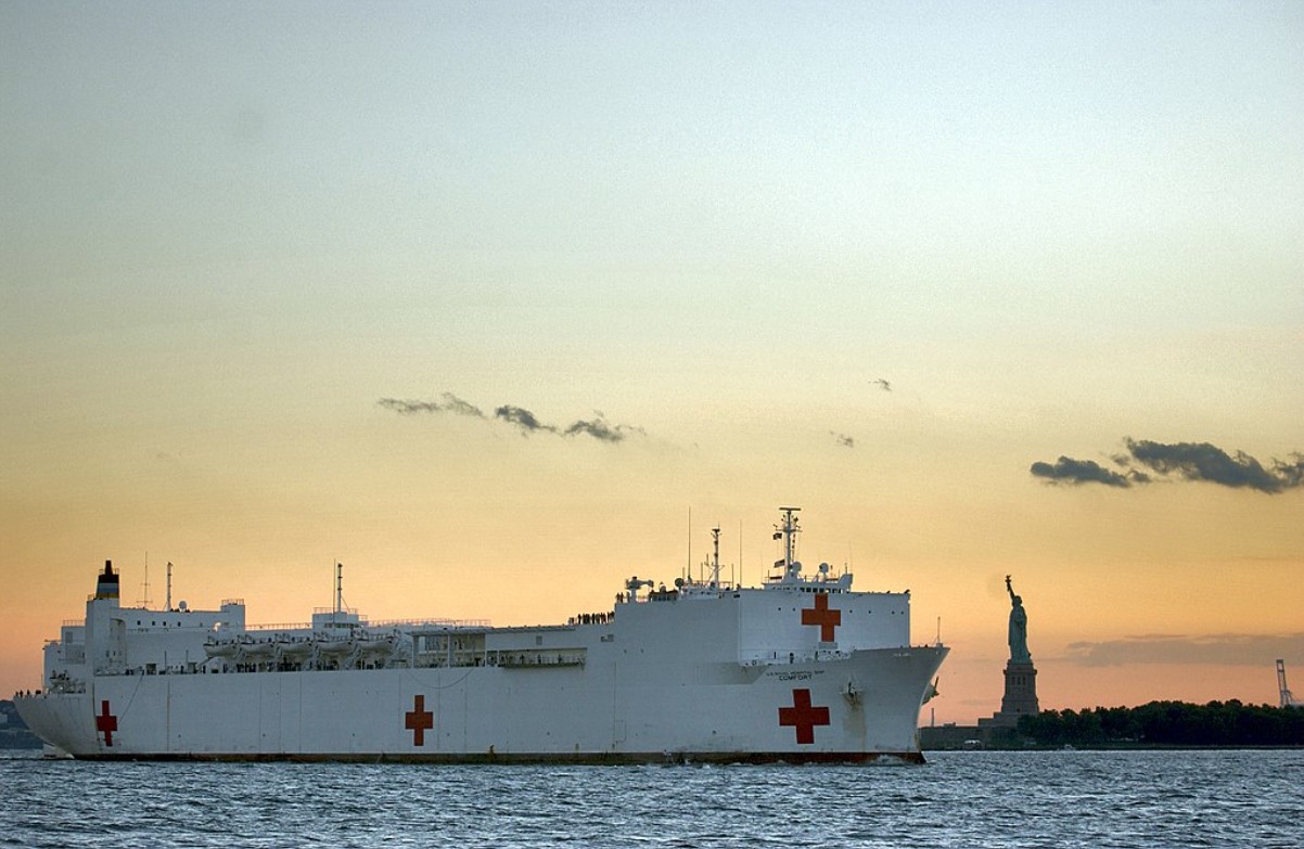 An image of the USNS Comfort sailing past the Statue of Liberty