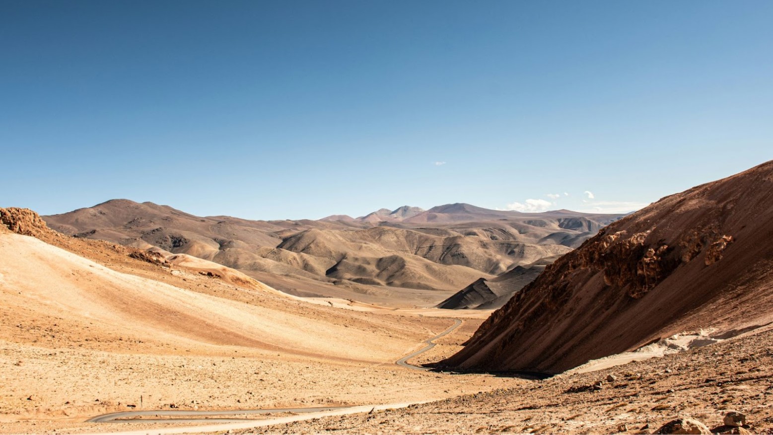 Hills, mountains, and a road seen in the daytime in the Atacama Desert in Chile.