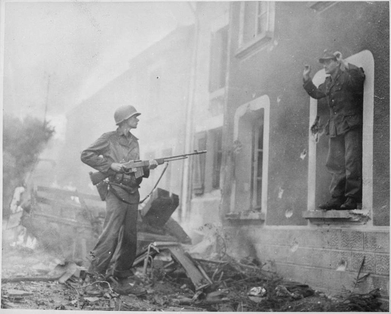 A German soldier captures an enemy soldier in the street during WWII