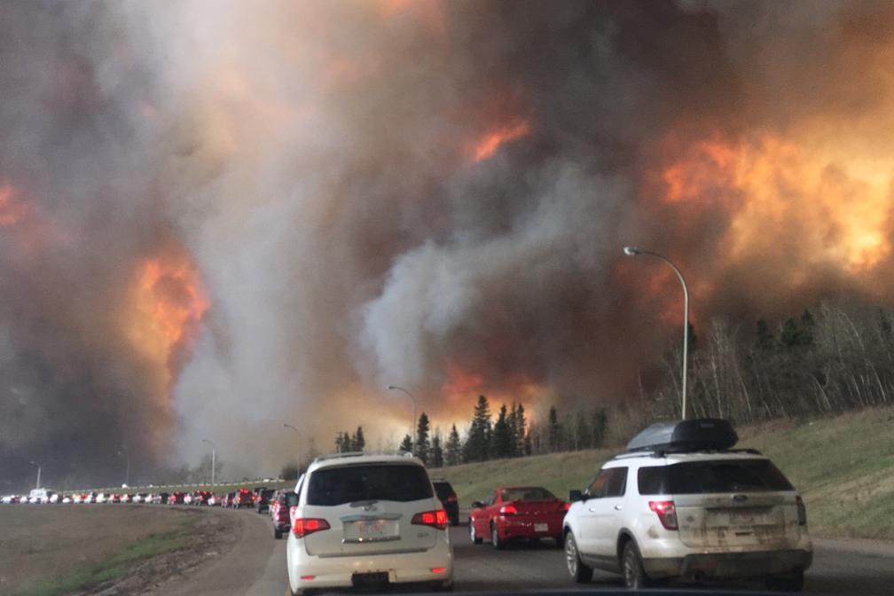 A long line of cars parked on a road as they attempt to leave their community following warnings