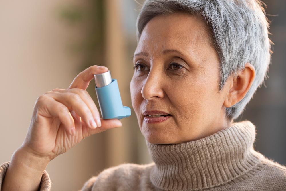 A woman in a woolly jumper is pictured using an inhaler