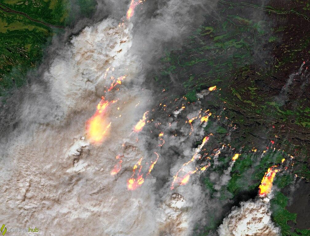 An aerial photograph of a large wildfire burning through the Canadian wilderness