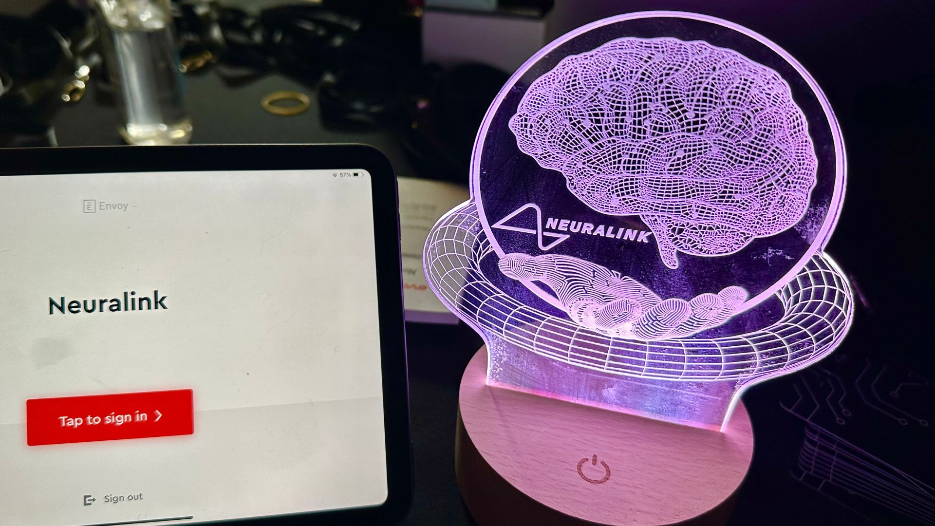 A Neuralink brain statue by a tablet.