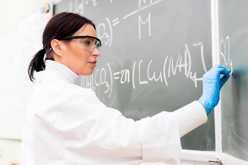 A woman is pictured solving an equation