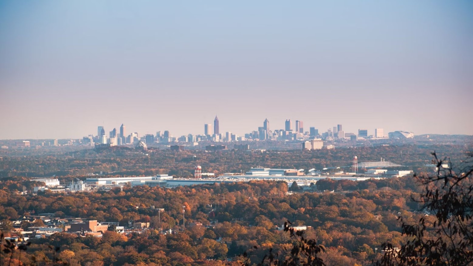 A view of a city in Georgia. In the background are skyscrapers next to autumn trees.