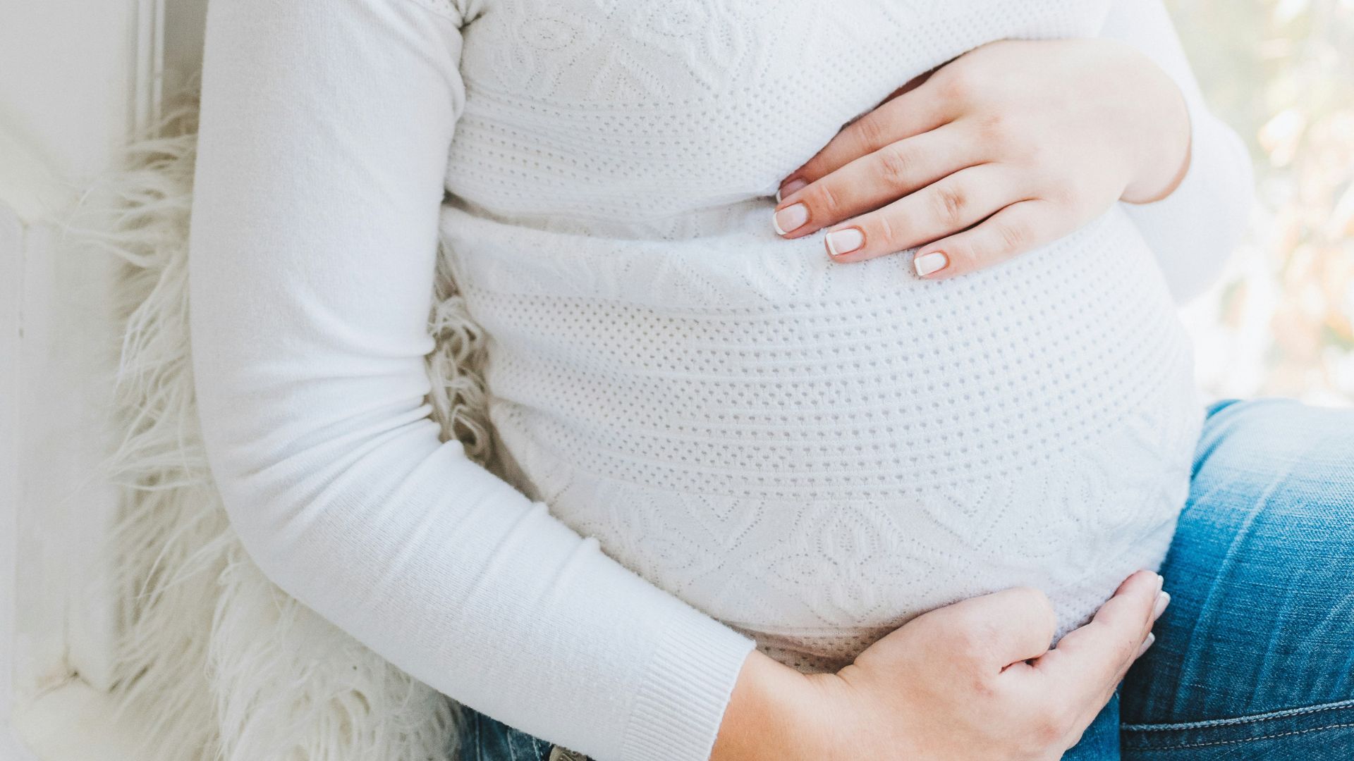 A close-up of a woman’s baby bump.