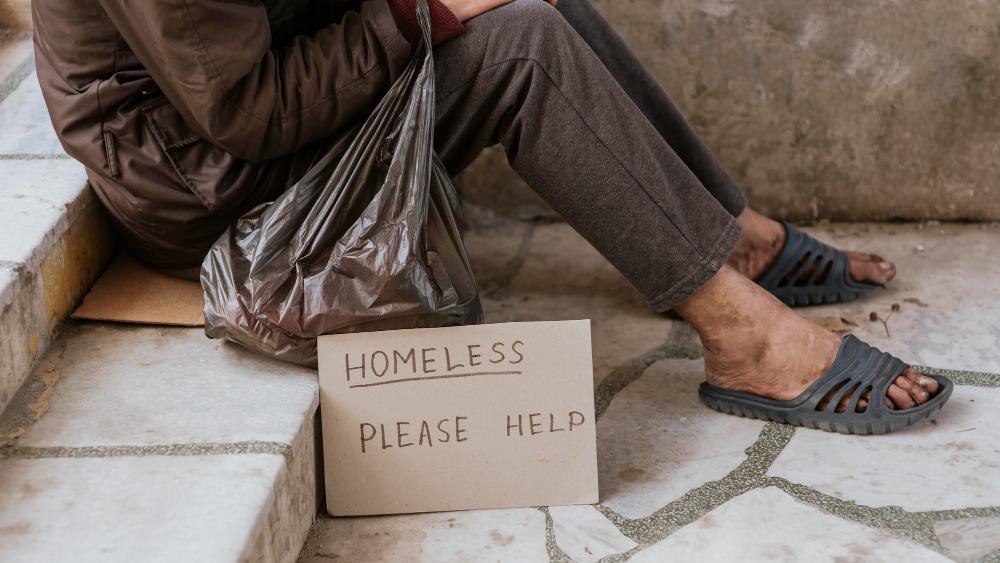 A homeless man is pictured on the street begging for help