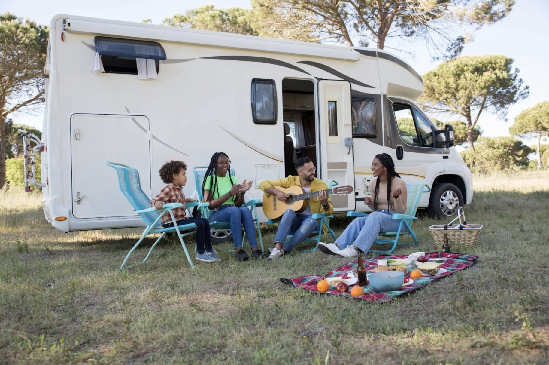 An image of several people sitting outside an RV