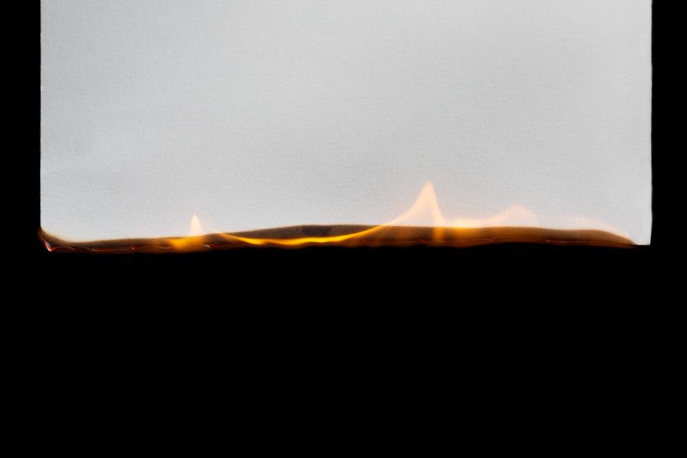 A smoldering fire is pictured with a dim flame