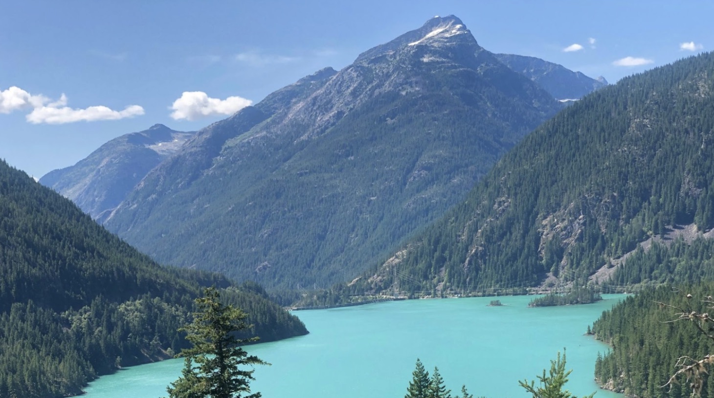 A body of water seen in front of hills and a mountain at Diablo Lake, Washington.