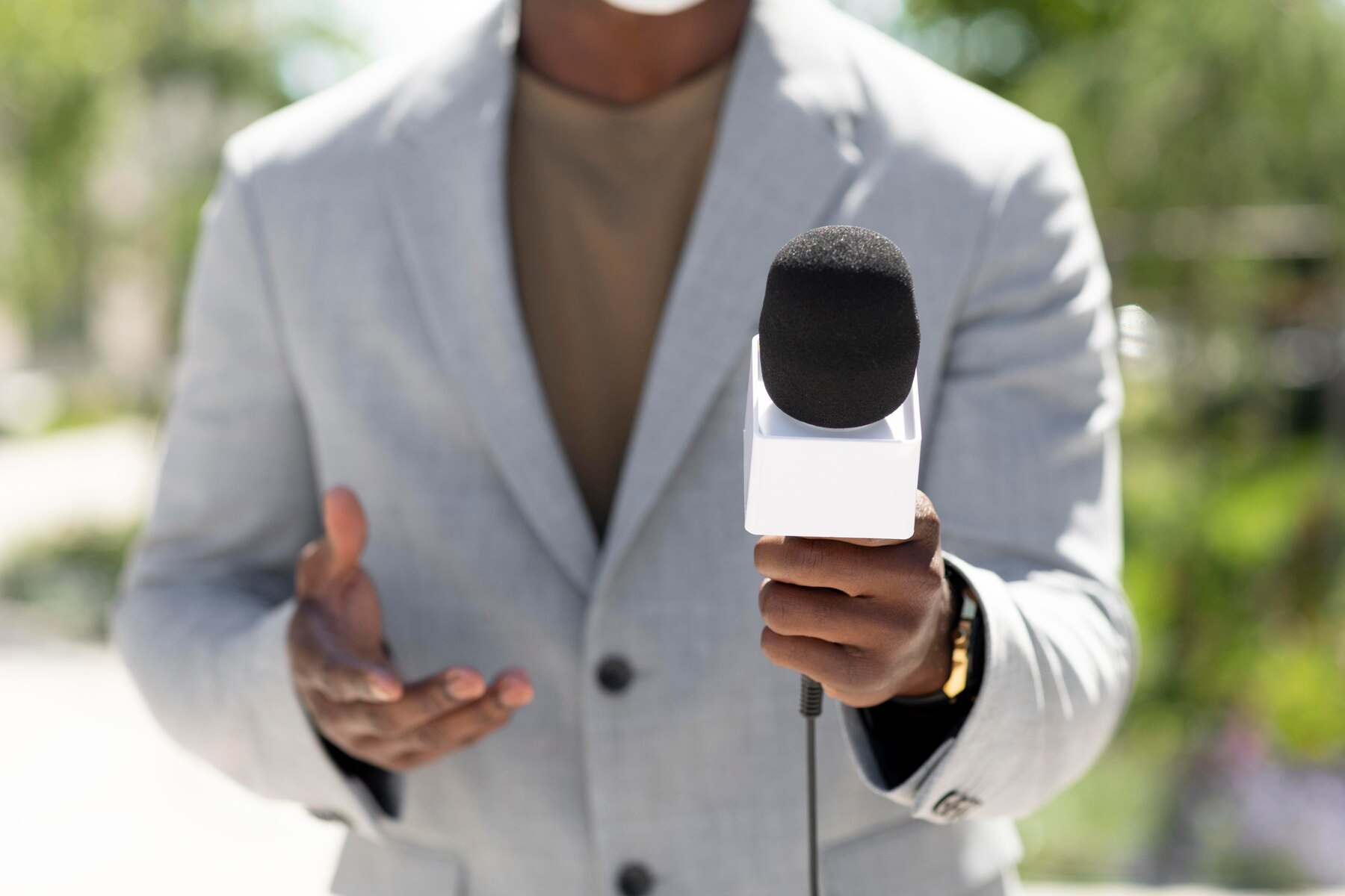 Journalist holding microphone. No face is shown.