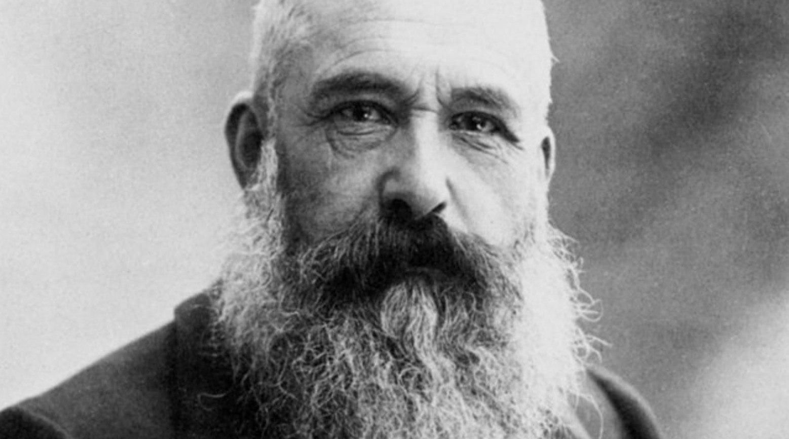 A black and white image of Claude Monet. He has a long beard and mustache.