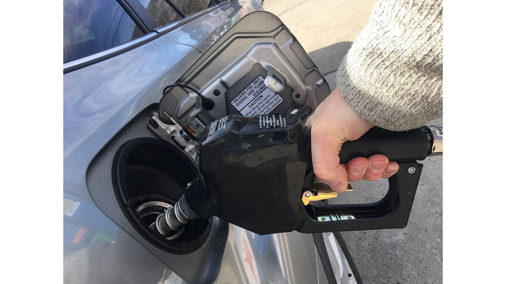 A person pumps gas into their car.