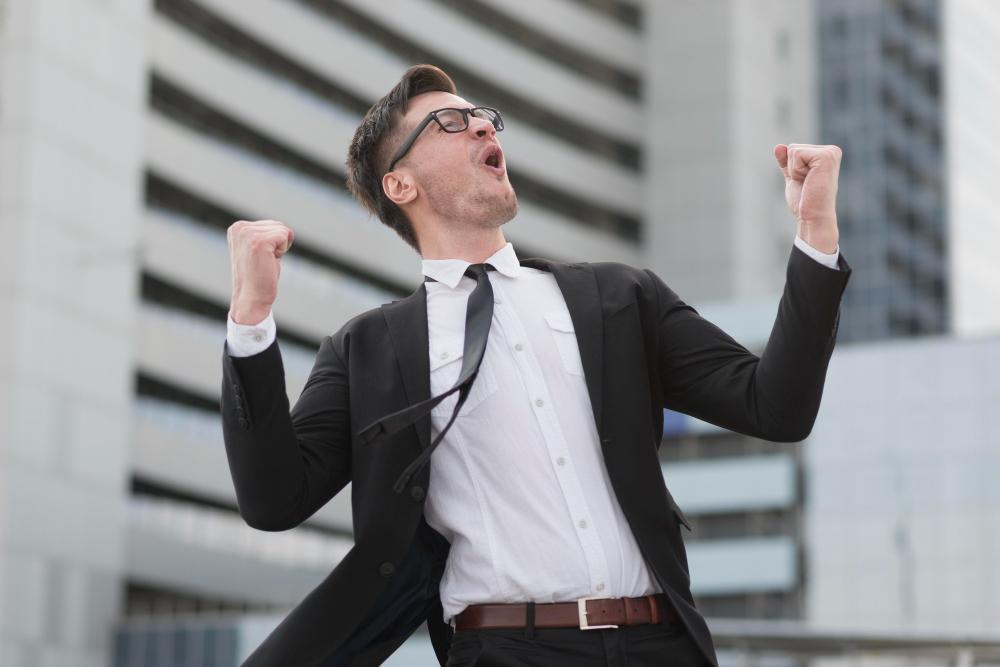 A man in a suit is pictured celebrating after accomplishing his goals