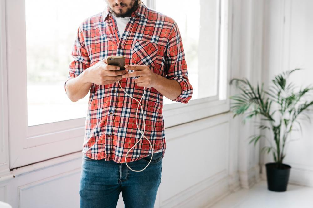 A man is pictured using a smartphone in a room