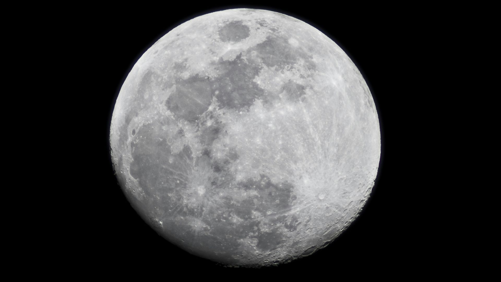The lit-up moon seen in black space.