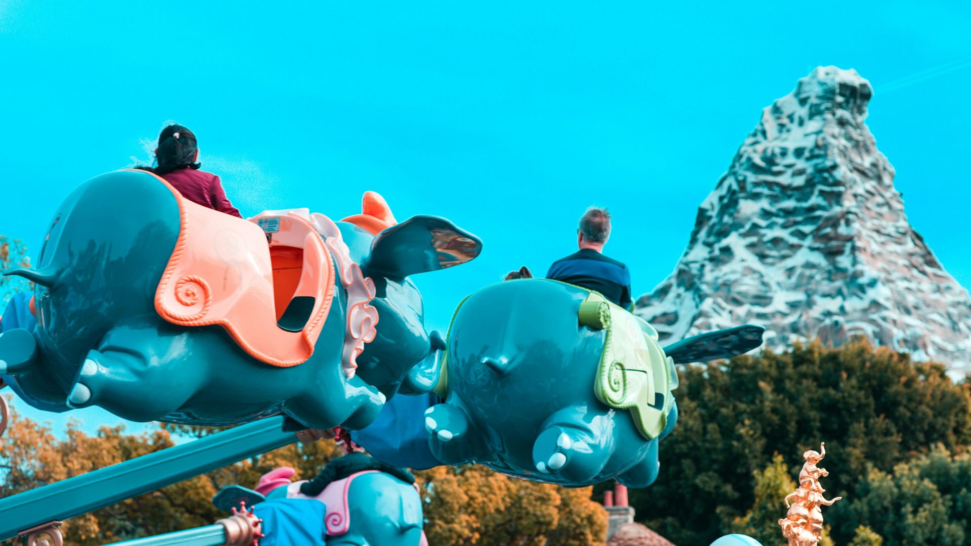 People riding a ride at Disneyland in the daytime.
