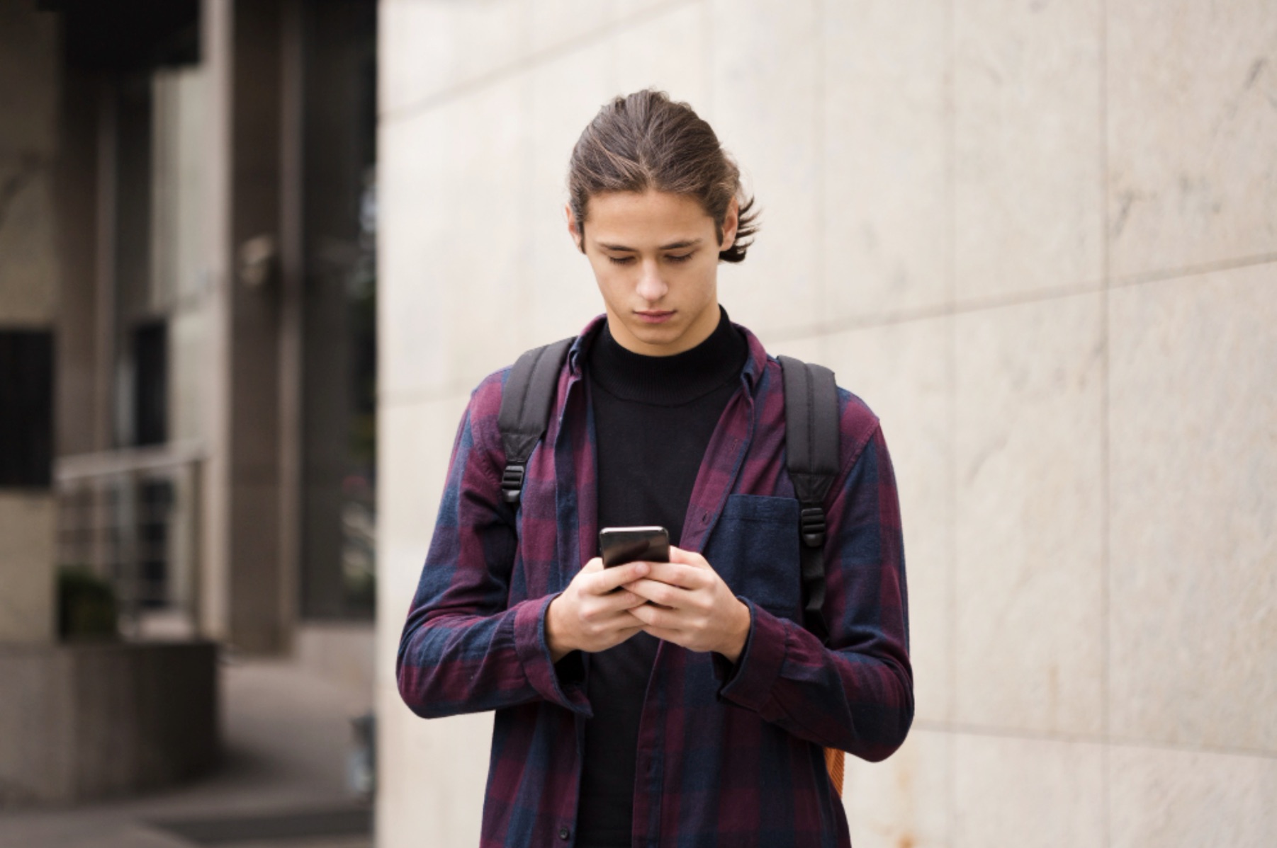 A man is pictured using his smartphone to reply to messages on social media