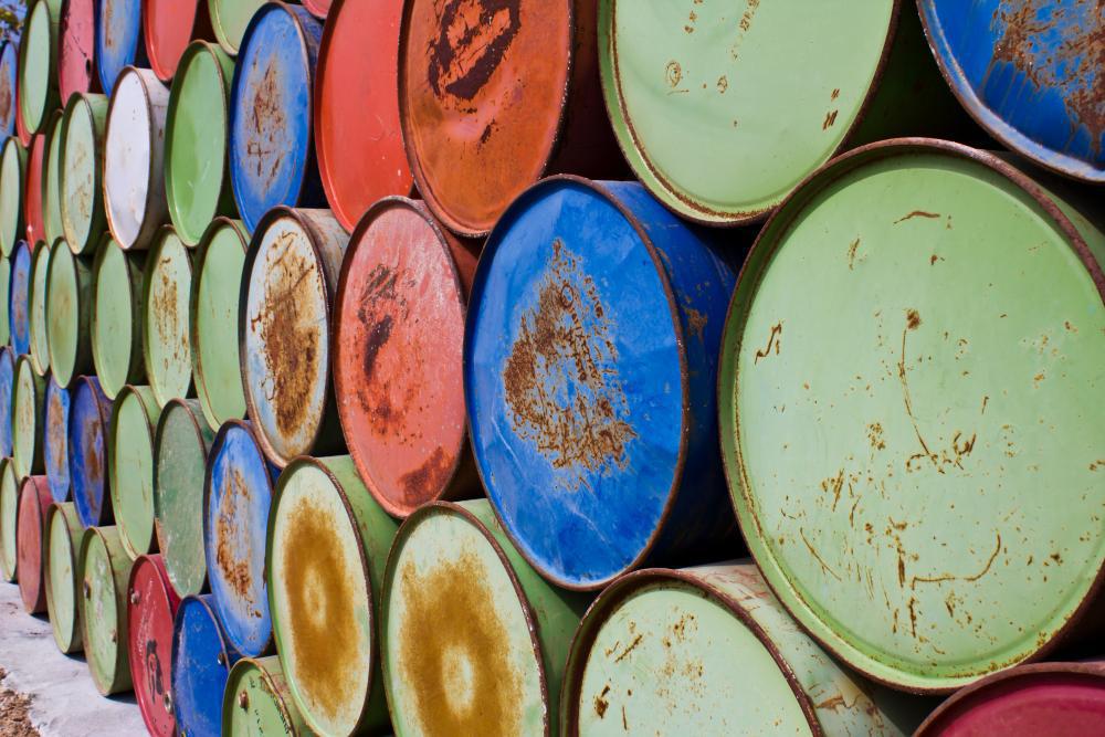 A photograph of numerous gasoline barrels stacked upon one another