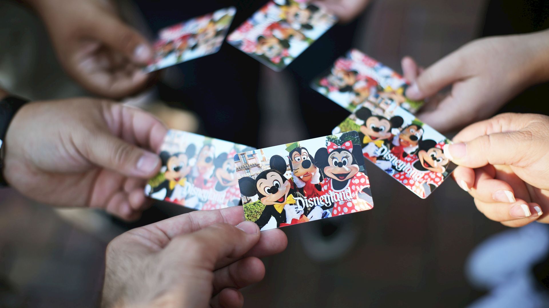 Many people holding out their Disneyland passes.