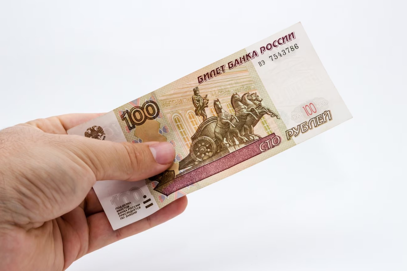 hand holding 100 Russian Rubles