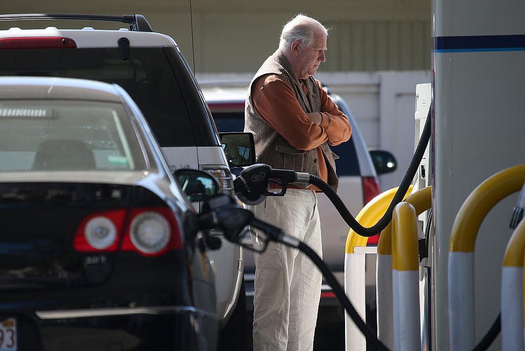 An older man is pictured pumping gas